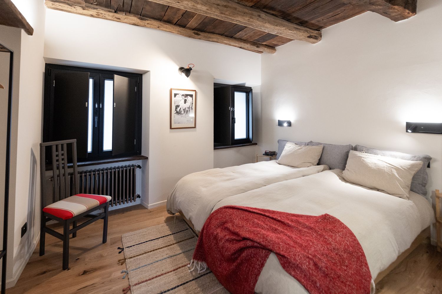 Bedroom with red throw and private bathroom area